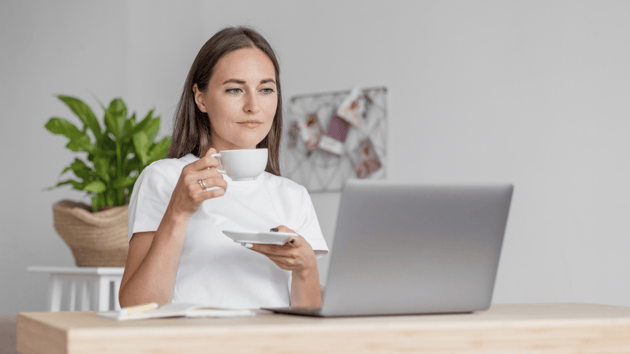 a teacher with a mug sitting at desk