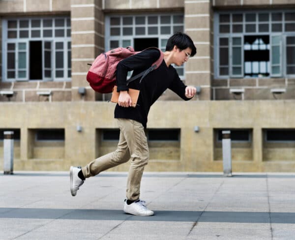 young student who is tardy running to class