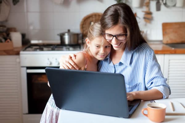 Working from home office with kid. Happy mother and daughter shopping online, using laptop together. photo-of-mom-and-daughter-using-laptop-and-browsing-school-choice