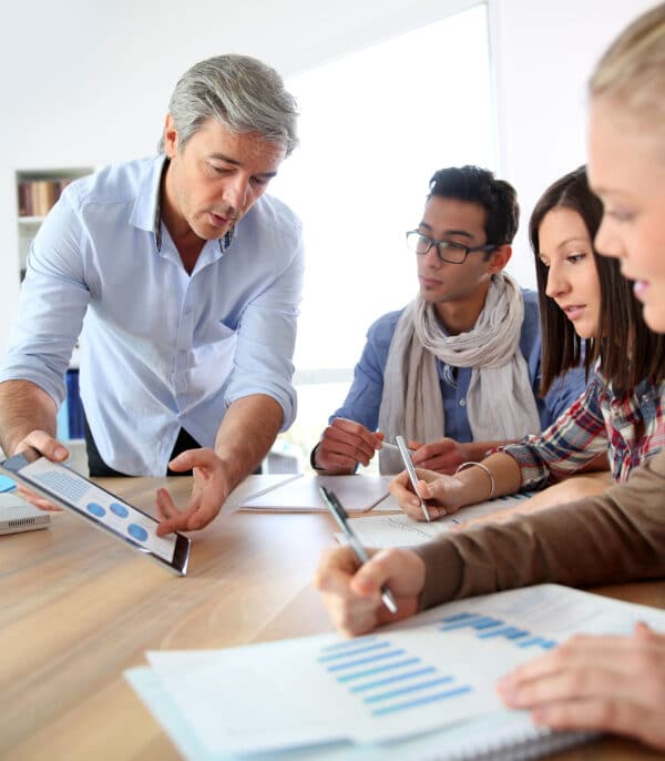 four people at a table discussing how to improve a school website