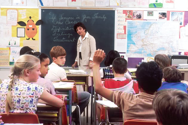 classroom full of students being taught by a teacher