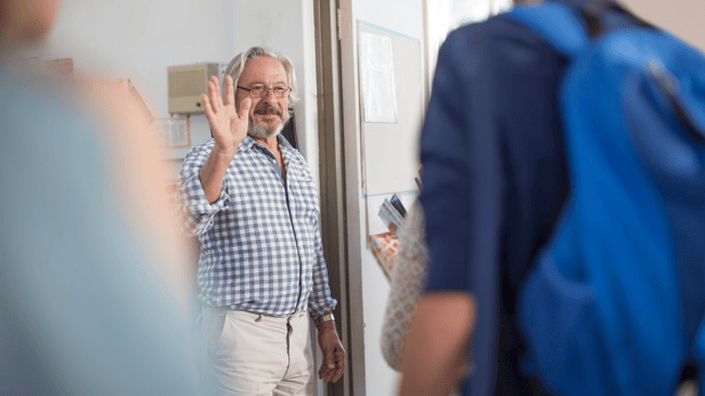 smiling teacher waving to students