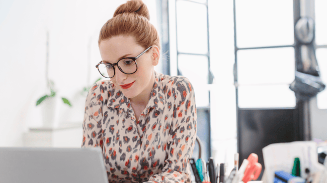 woman sitting at computer and slightly smiling