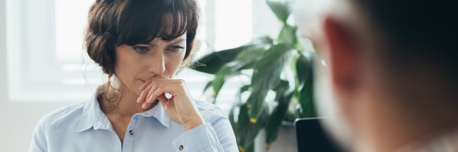 beautiful-worried-woman-sitting-at-a-desk-in-front-2021-08-27-16-16-43-utc-1