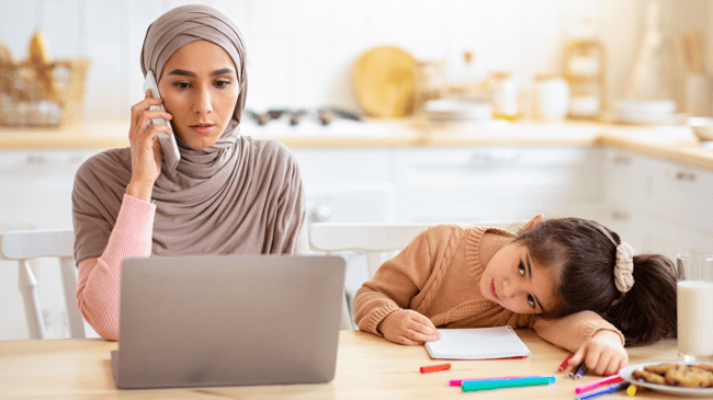 busy mom on phone with daughter beside her