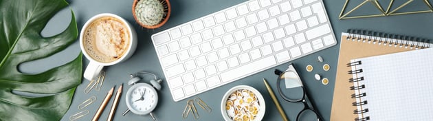 above view of keyboard and coffee for school social media manager