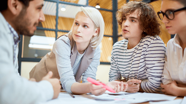 four people talking to discuss a school swot analysis