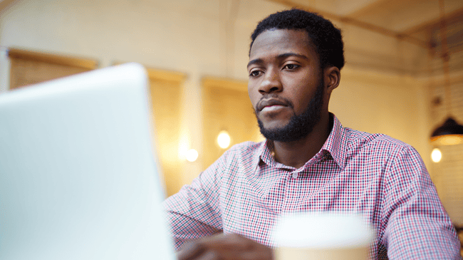 guy sitting at computer writing for a school blog