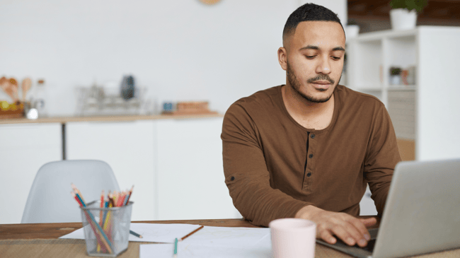 man sitting at computer reading about cybersecurity in k12