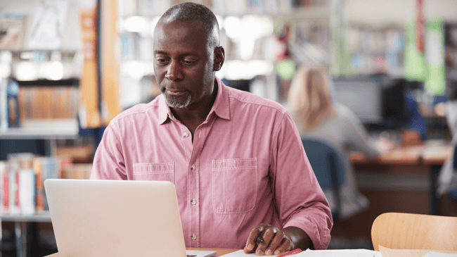 mature-male-working-on-laptop-in school