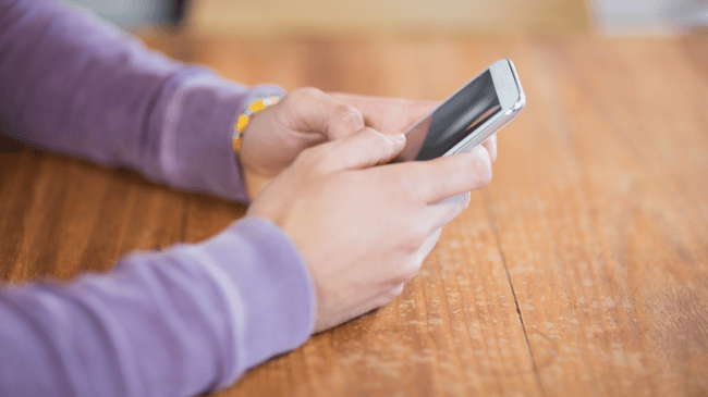 person wearing a parent shirt on their mobile phone