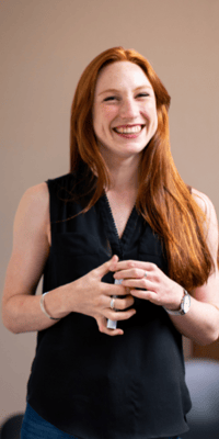 smiling redhead teacher with marker in hand