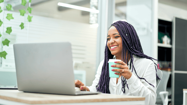 smiling-businesswoman-sitting-at-office-desk-holdi-2022-01-19-00-04-09-utc