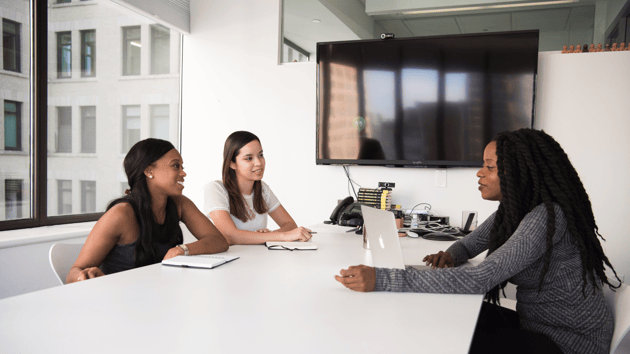 three women sitting at a table talking