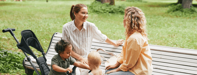 two mothers talking at the park about their older kids school