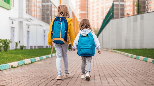 two young girls walking to school