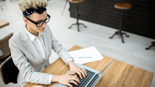 woman sitting at table on her computer