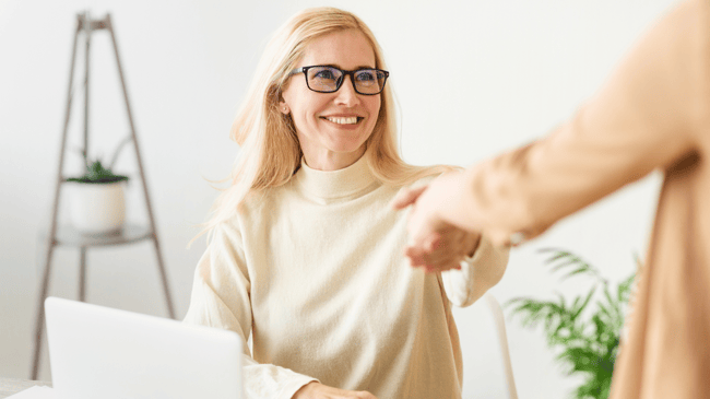 young woman shaking hands with someone off screen