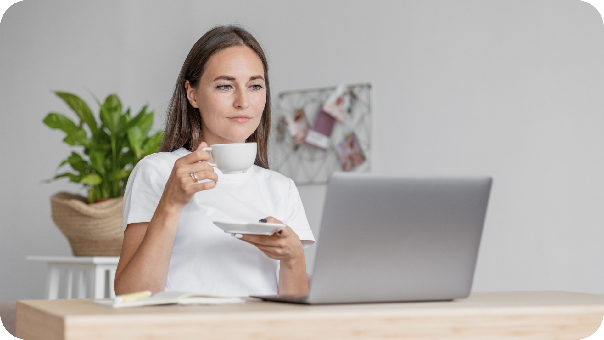 woman sitting at computer and sipping drink